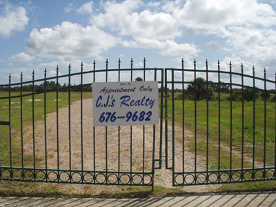 Gate to land sold by CJ's Realty, showing CJ's sign
